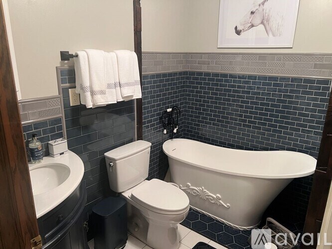 A white toilet sits next to a white bathtub in a bathroom.