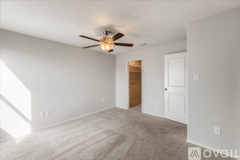 A room with a ceiling fan and carpeted floor.