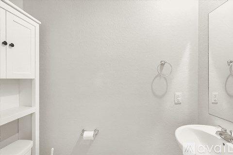 A white bathroom with a toilet, sink, and medicine cabinet.