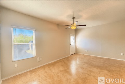 A room with a ceiling fan and a window with blinds.