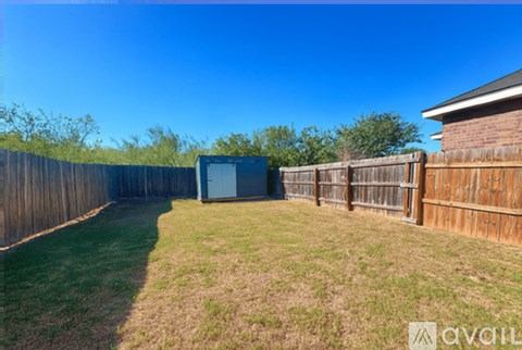 A backyard with a fence and a shed.