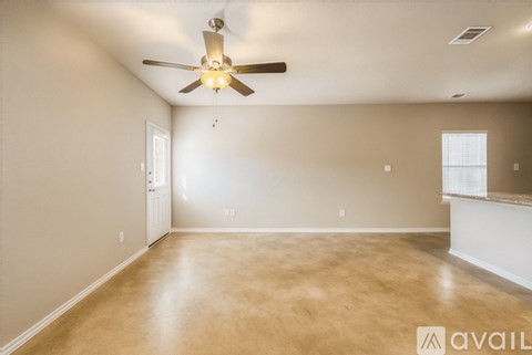 A spacious room with a ceiling fan and light fixture.