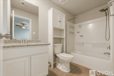 A white bathroom with a toilet, sink, and shower.