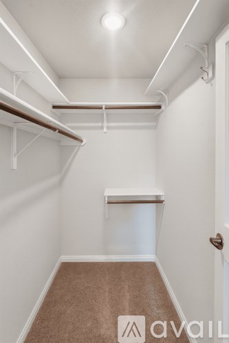 A small, empty room with a carpeted floor and white walls.