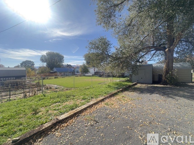 A sunny day at a grassy area with a railway track and a shed.