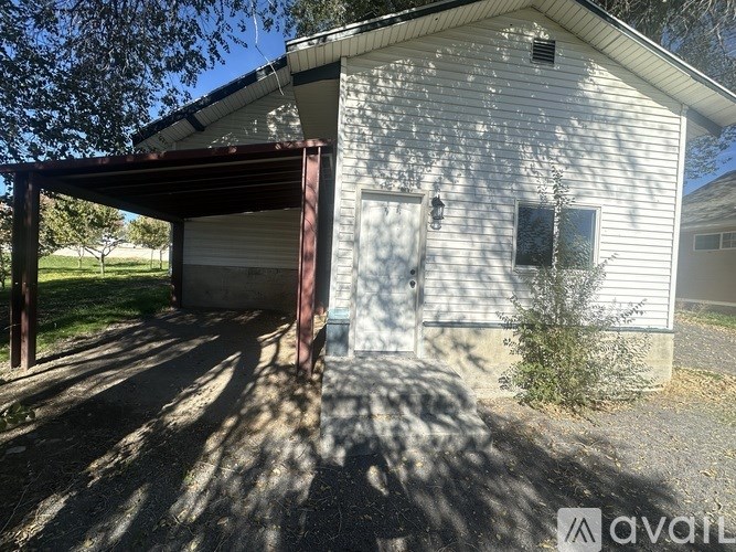 A house with a garage door open and a tree in front.