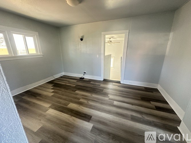 A room with wooden flooring and a ceiling fan.