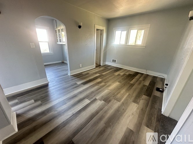 A room with wooden flooring and white walls.