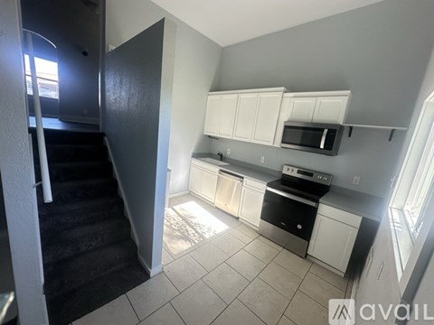 A kitchen with white cabinets and a black dishwasher.