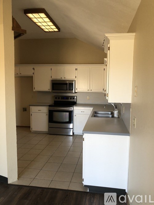A kitchen with white cabinets and stainless steel appliances.