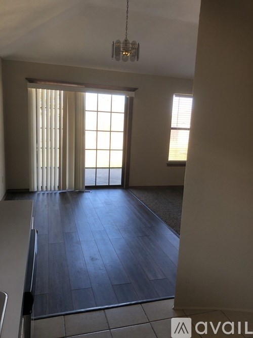 A room with a wooden floor and a chandelier.