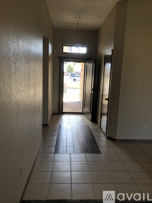 A hallway with a black tiled floor and white walls.