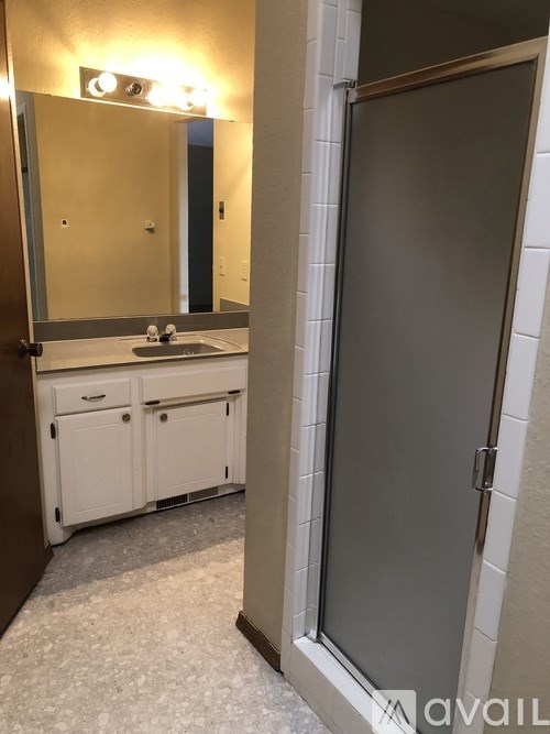 A bathroom with a sink, mirror, and cabinets.