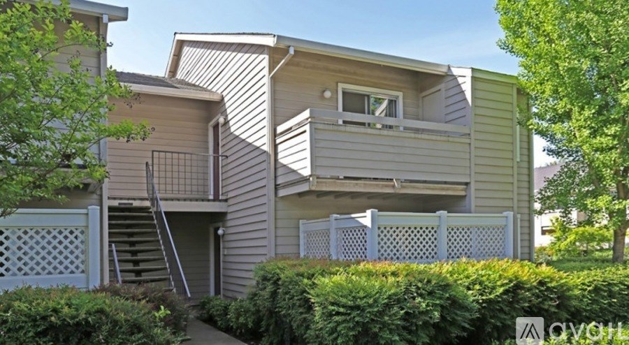 A house with a grey siding and a white window.