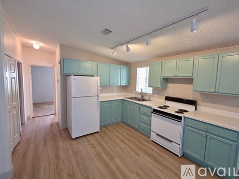 A kitchen with white appliances and light wood floors.