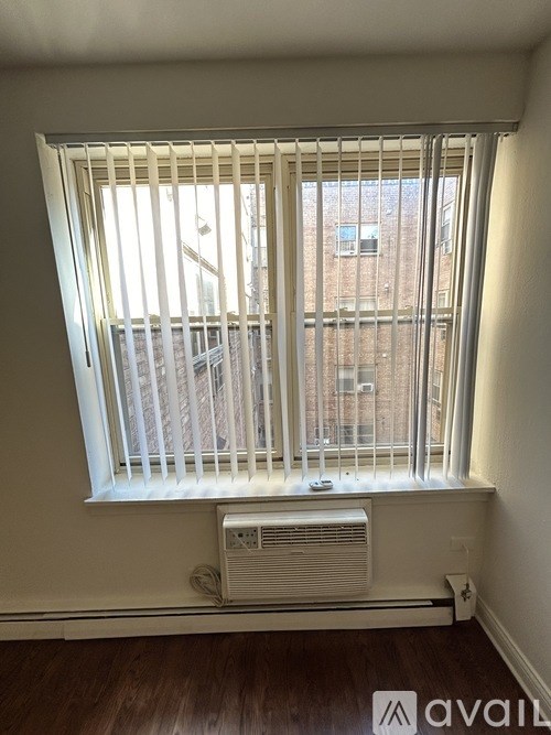 A window with a white air conditioner unit beneath it.
