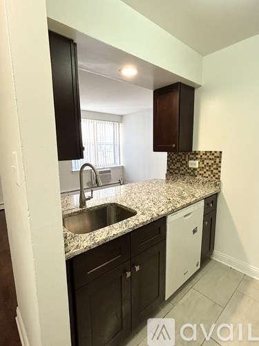 A kitchen with granite countertops and white appliances.