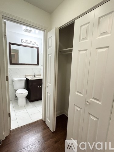 A bathroom with a toilet, sink and mirror.