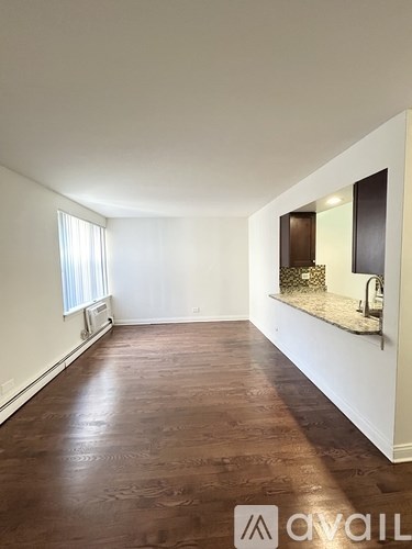 A room with brown flooring and white walls.