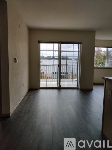 A room with a large window and wooden floors.