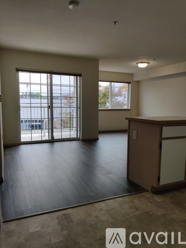 A room with a large window and a wooden floor.
