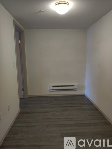 A room with a wooden floor and a white wall.