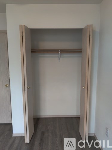 A white closet with a hanger bar and a door.