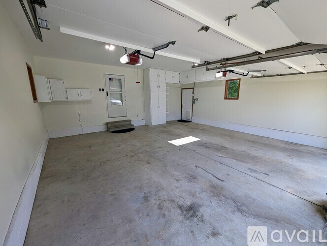 A large empty room with a concrete floor and white walls.