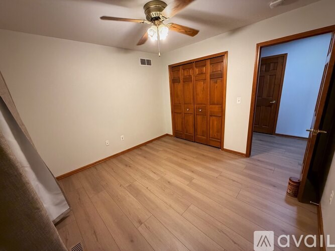 A room with wooden floors and a ceiling fan.