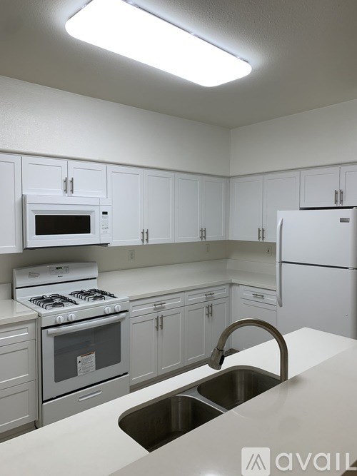 A kitchen with white cabinets and appliances.