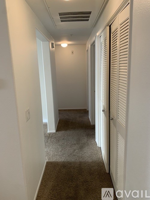 A long hallway with a carpeted floor and white walls.