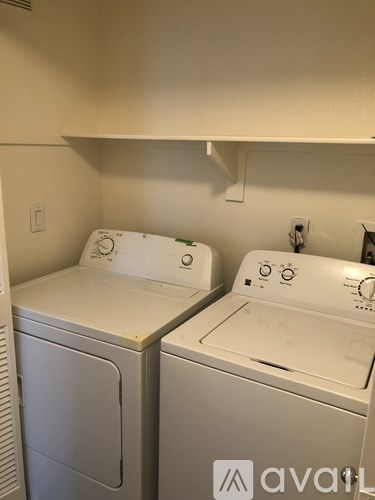 Two front loading washing machines in a small laundry room.