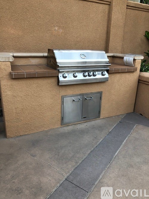 A stainless steel grill is attached to a tan wall.