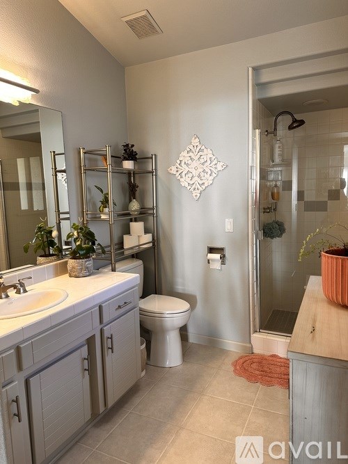 A bathroom with a toilet, sink, and shower.