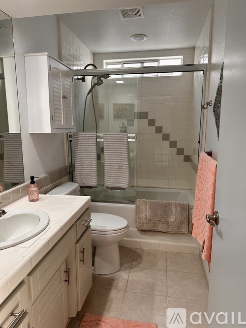 A bathroom with a toilet, sink, and shower.