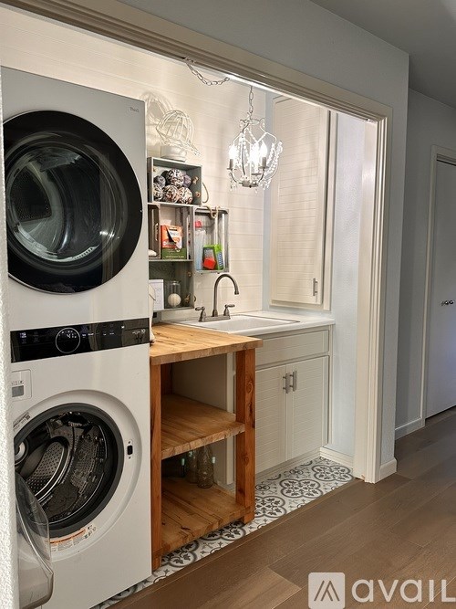 A washing machine is in the front of a small laundry room.