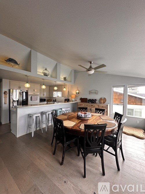 A kitchen with a dining table and chairs.