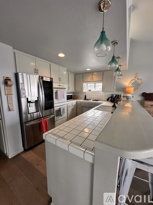 A kitchen with a white counter and stainless steel appliances.