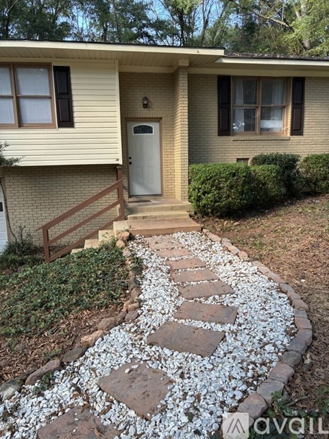 A house with a white door and a small garden with a stone pathway.