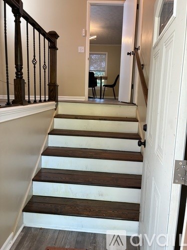 A staircase with a white door at the bottom.