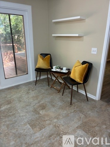 A room with a table and two chairs and a window.