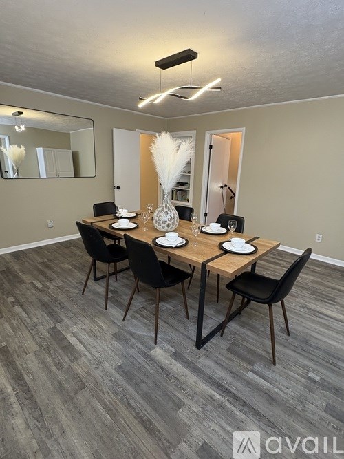 A dining room with a wooden table and chairs.