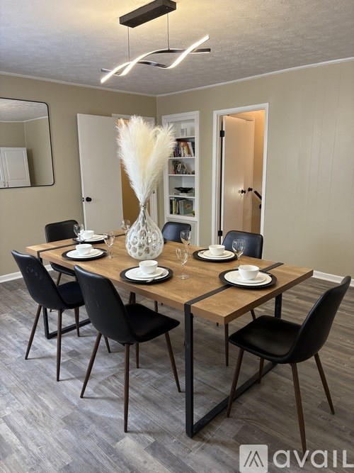 A dining room with a wooden table set for two.