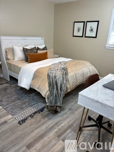 A bedroom with a bed, desk, and chair.