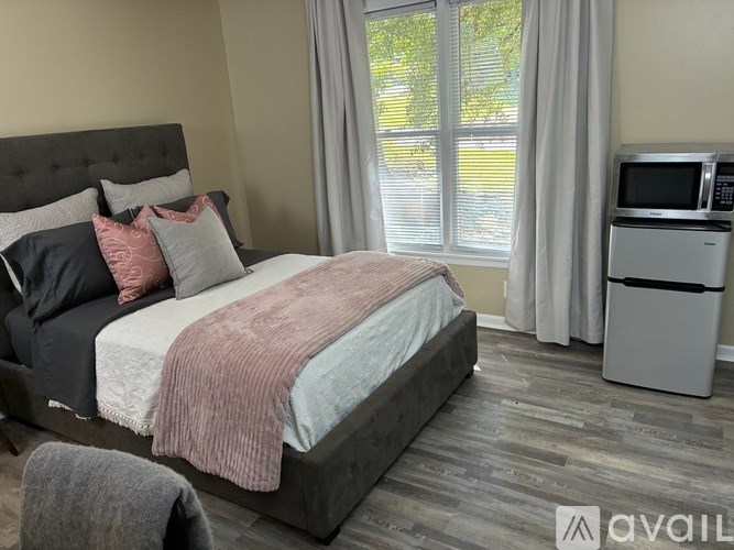 A bedroom with a large bed and a microwave oven.