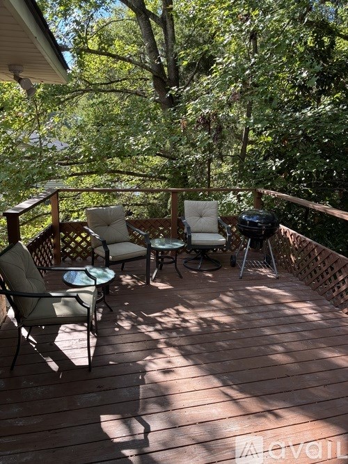 A wooden deck with chairs and a table.