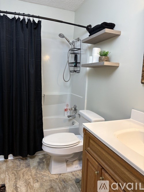 A bathroom with a toilet, sink, and shower.