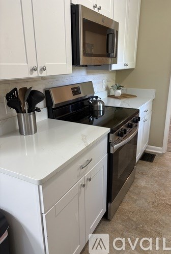 A kitchen with white cabinets and a black stove top.