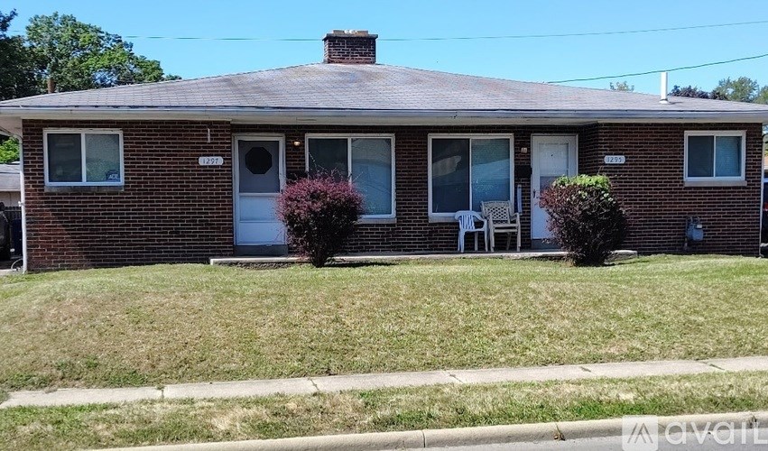 A brick house with a white door and a small porch.