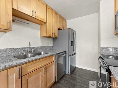A kitchen with wooden cabinets and a granite countertop.